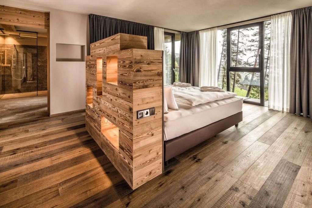 Geräumiges Schlafzimmer mit Holzwänden und großem Doppelbett in der Treetop Suite