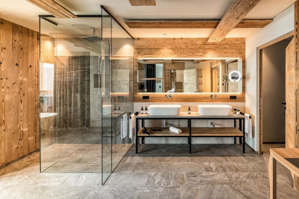 Modernes Badezimmer mit Doppelwaschbecken und großer Regendusche in der Treetop Suite