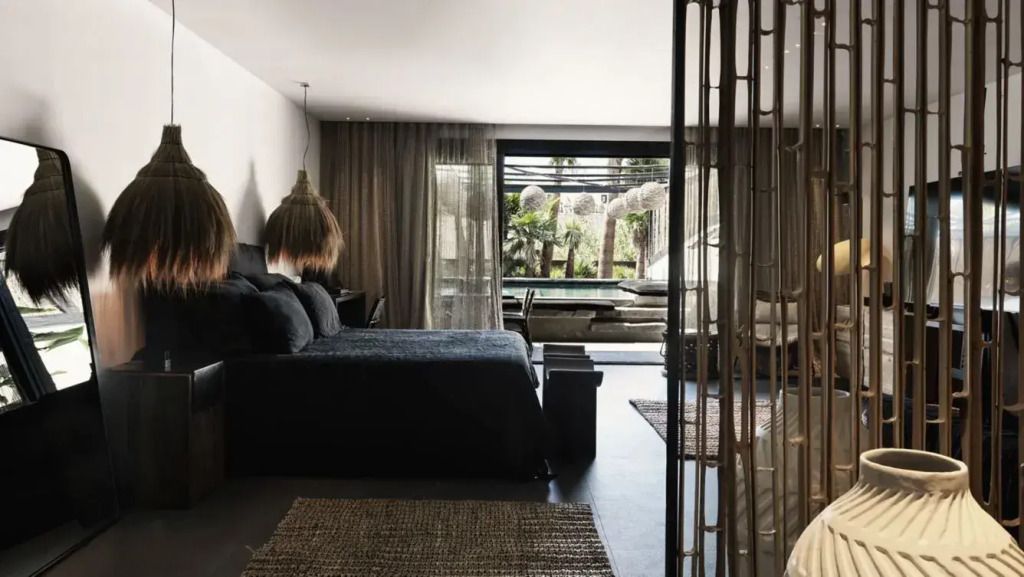 Elegantes Schlafzimmer mit Doppelbett und Gartenblick durch große Fenster.
