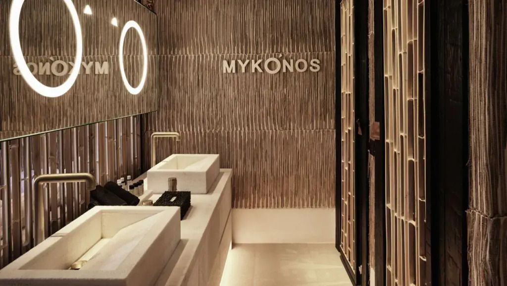 Stylisches Badezimmer mit modernem Waschtisch und Mykonos-Schriftzug