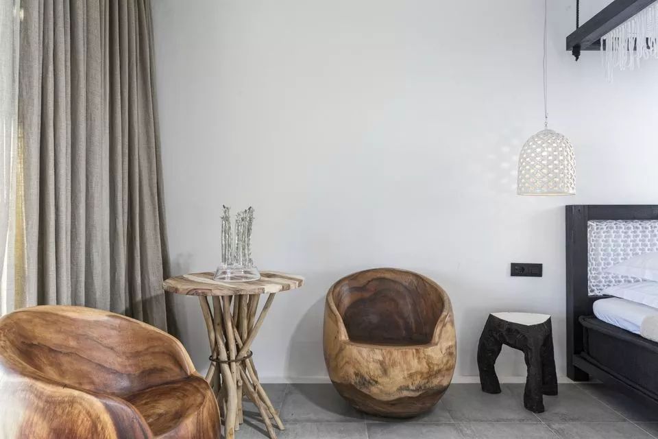 Schicke Sitzecke mit einzigartigen Holzsesseln im Hotelzimmer