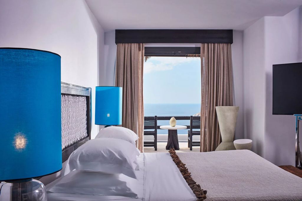 Elegantes Zimmer mit Doppelbett und Meerblick vom Balkon im Myconian Utopia