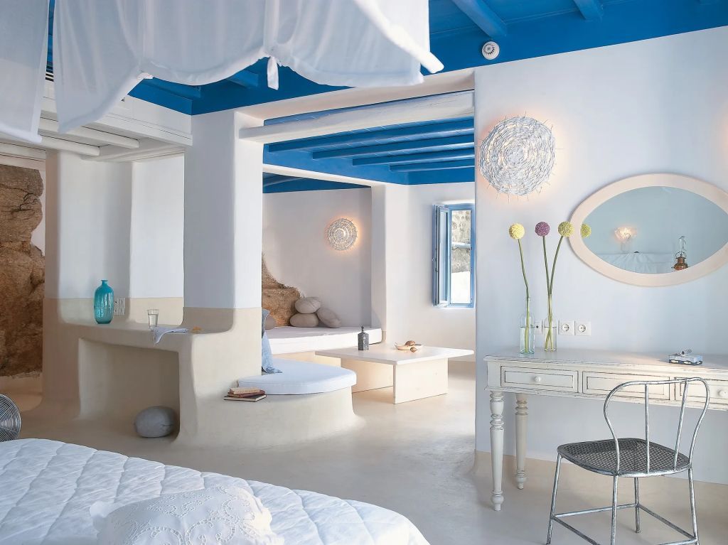 Offener Wohn- und Schlafbereich mit blauen Deckenbalken im Mykonos Blu Resort