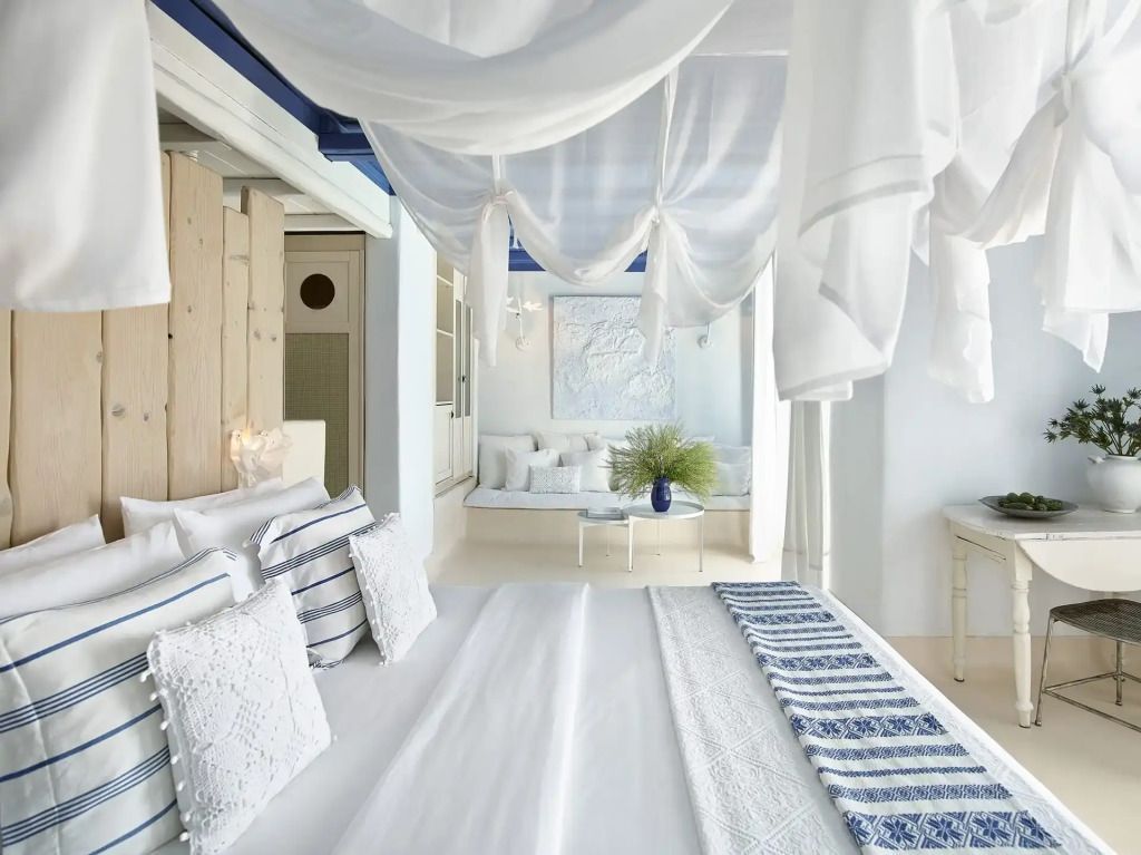 Helles Schlafzimmer in der Cobalt Blu Villa mit weißen Vorhängen und blauen Akzenten.