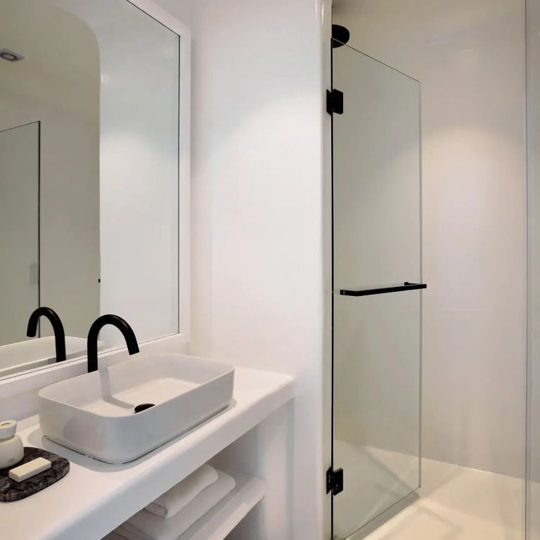 Modernes Badezimmer mit Glasduschwand und schlichtem Waschbecken