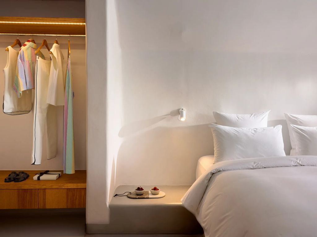 Elegantes Schlafzimmer mit teilweise offener Garderobe und Doppelbett