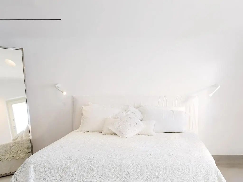 Modernes Doppelbett in einem stilvoll eingerichteten Raum in Weiß