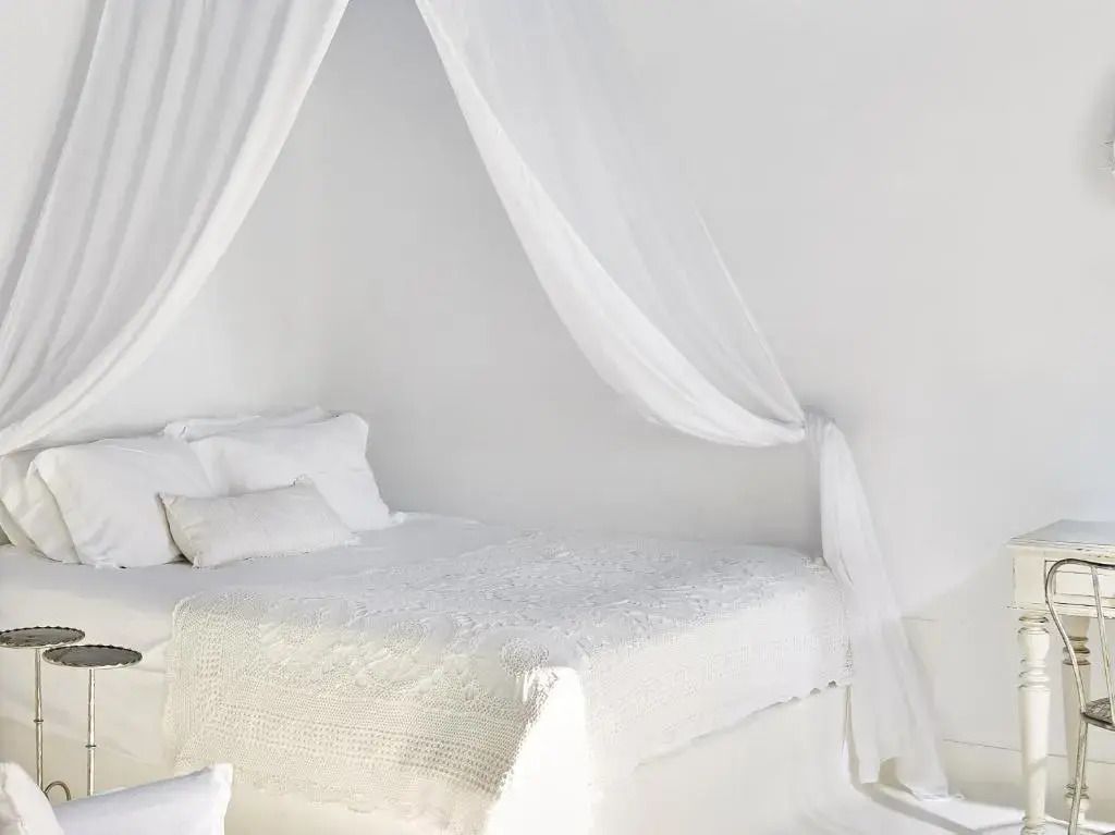Romantisches Himmelbett mit transparentem Baldachin in Weiß