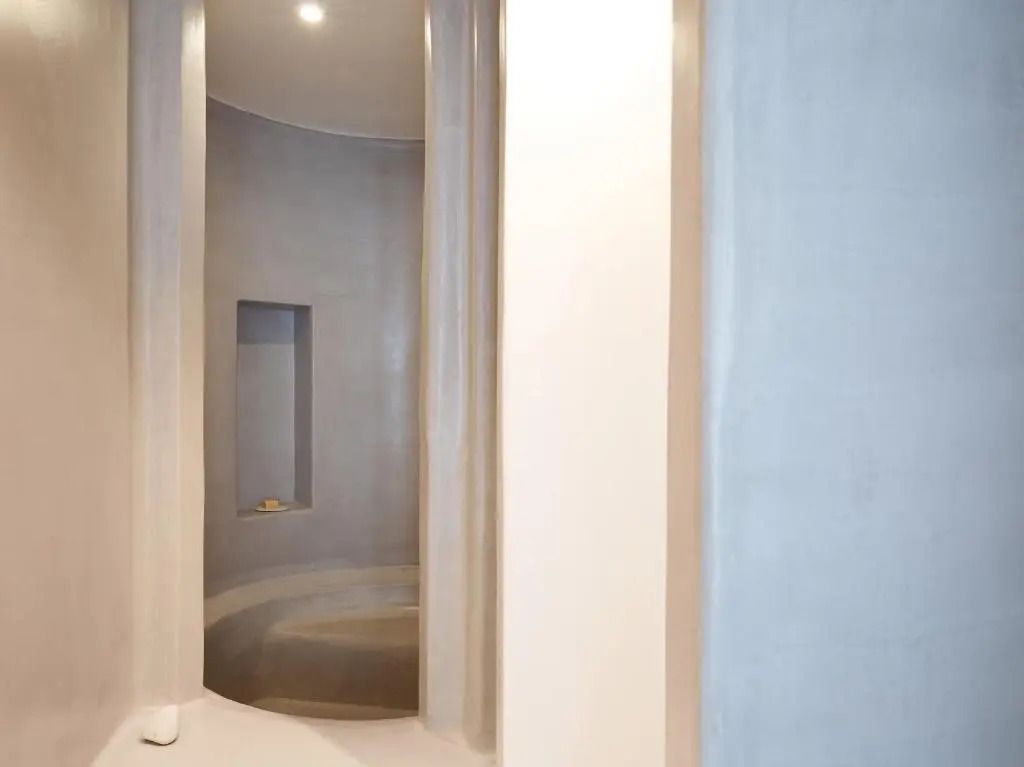 Moderne, minimalistische Dusche im Mykonos Blu Apartment mit sanften Rundungen