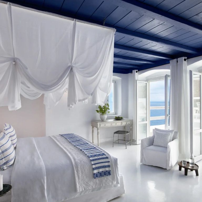 Helles Schlafzimmer mit Himmelbett und Meerblick im Mykonos Blu Royal Blu Mansion