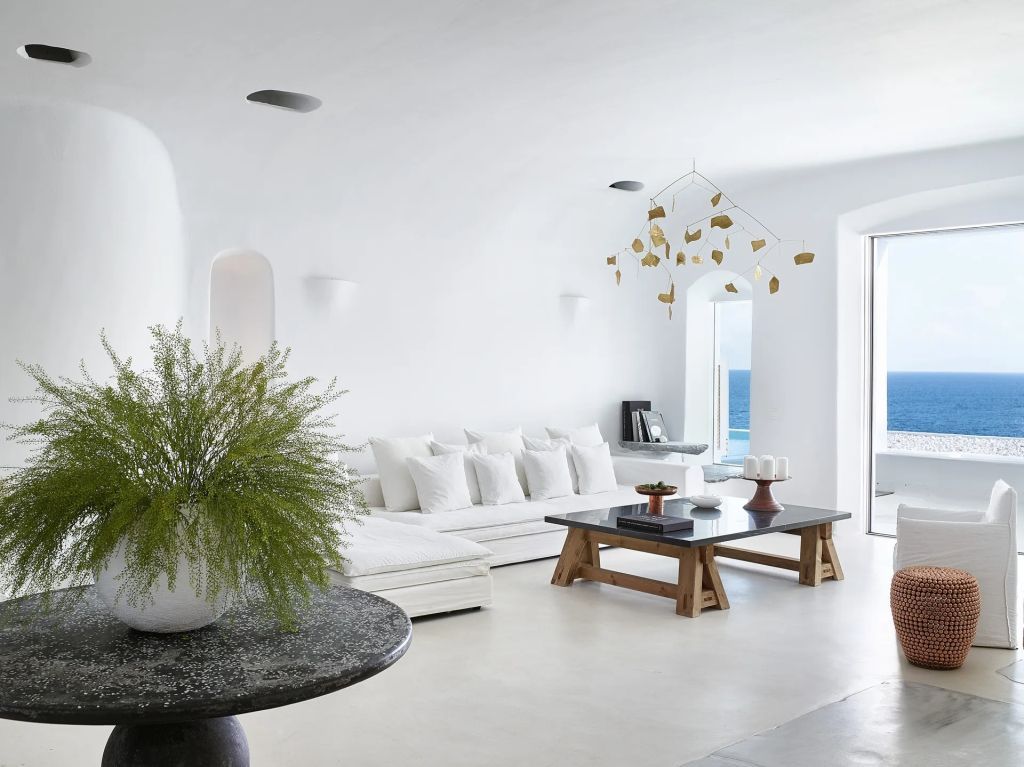 Eleganter Wohnbereich mit weißem Sofa und Meerblick im Mykonos Blu Royal Blu Mansion