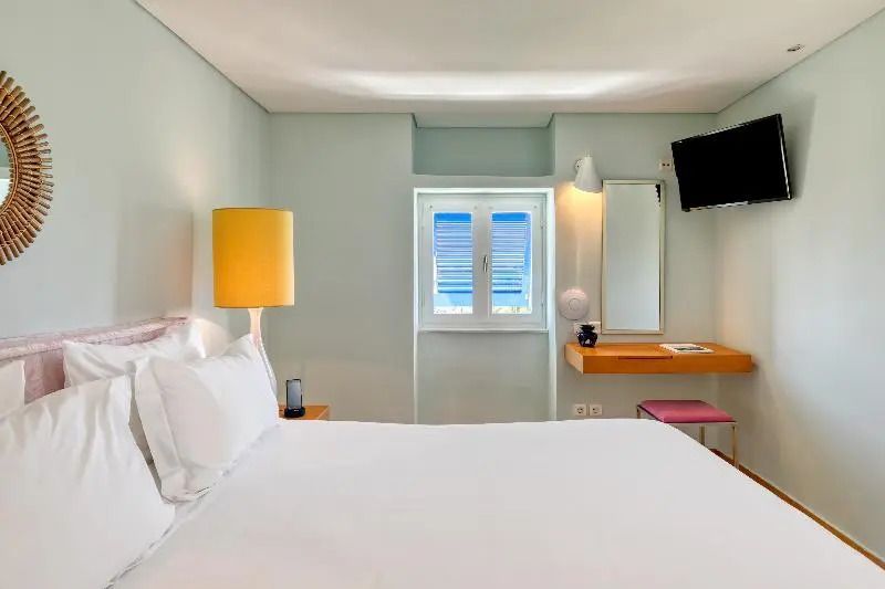 Modernes, lichtdurchflutetes Zimmer mit Schreibtisch und Flachbildfernseher