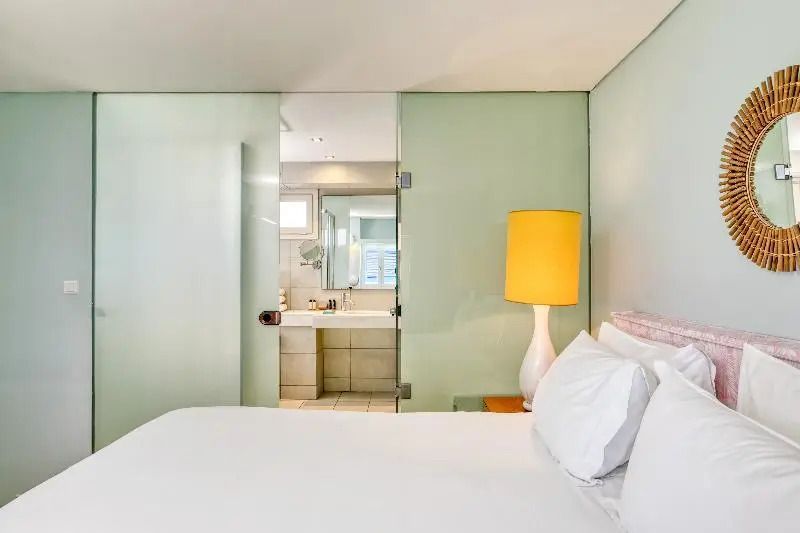 Doppelzimmer mit Bett und Blick ins stilvolle Badezimmer