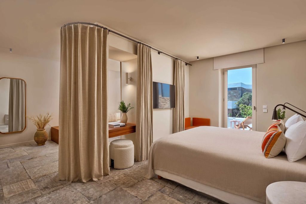 Schlafzimmer der Deluxe Suite mit Blick auf den Balkon und Garten