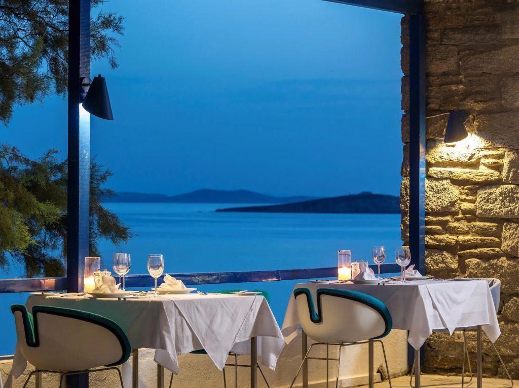 Elegante Terrasse mit Meerblick und gedeckten Tischen im Abendlicht