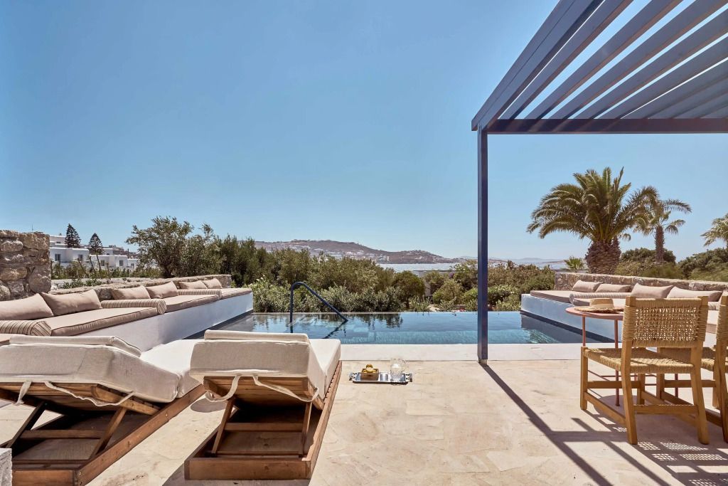 Luxuriöser Pool mit Liegen und Meerblick bei sonnigem Wetter