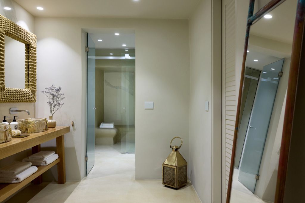 Elegantes Badezimmer mit Glasdusche und goldener Laterne in einer Villa.