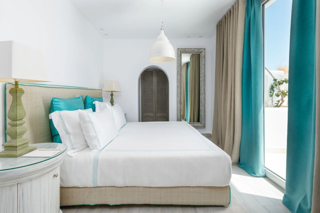 Geräumiges Schlafzimmer mit großen Kissen und türkisfarbenen Akzenten.