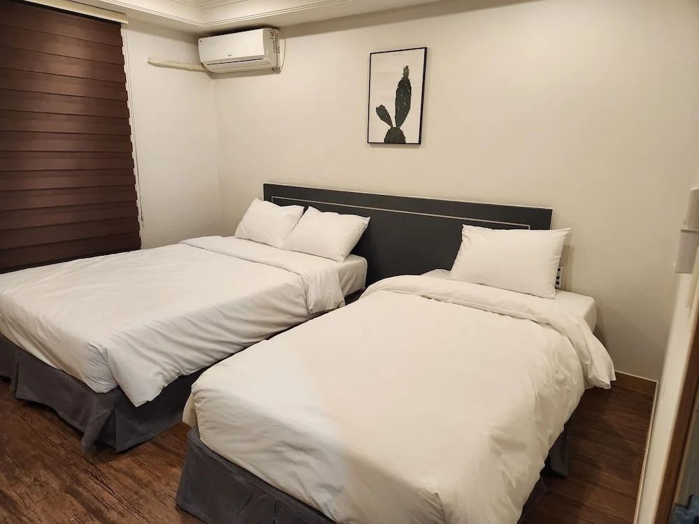 Deluxe Doppelzimmer mit zwei Einzelbetten, moderner Einrichtung und Wandkunst.