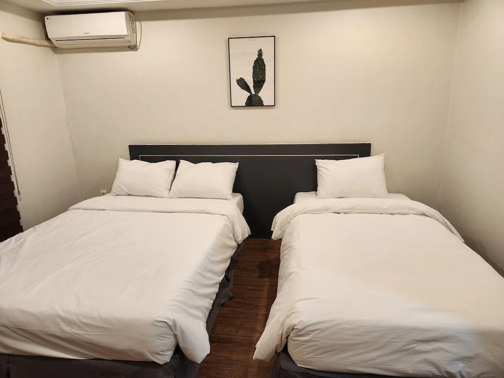 Doppelzimmer mit zwei Einzelbetten, künstlerischem Bild an der Wand.