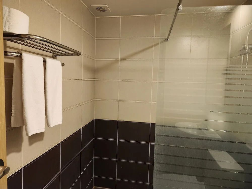 Badezimmer mit moderner Fliesenauswahl und Handtüchern.