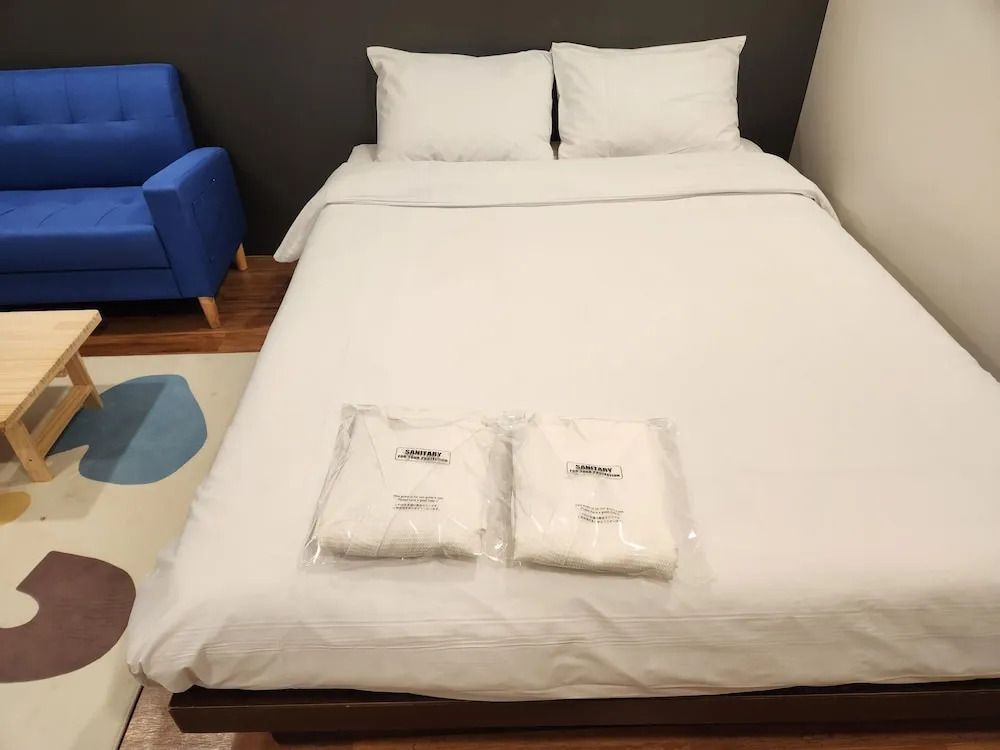 Blick auf das gemütliche Doppelbett mit frischen Handtüchern im Hotelzimmer.