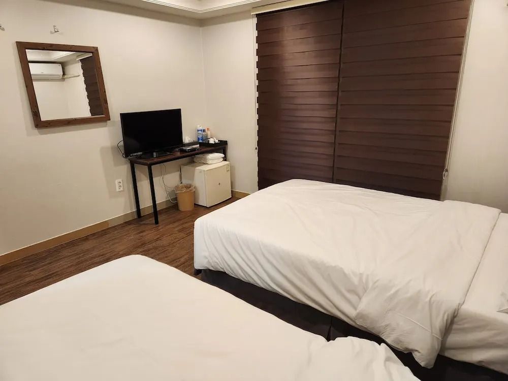 Standard Doppelzimmer mit zwei Einzelbetten und einem kleinen Fernseher