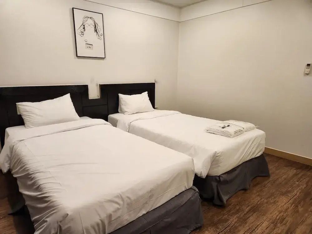 Zwei Einzelbetten in einem schlicht dekorierten Hotelzimmer