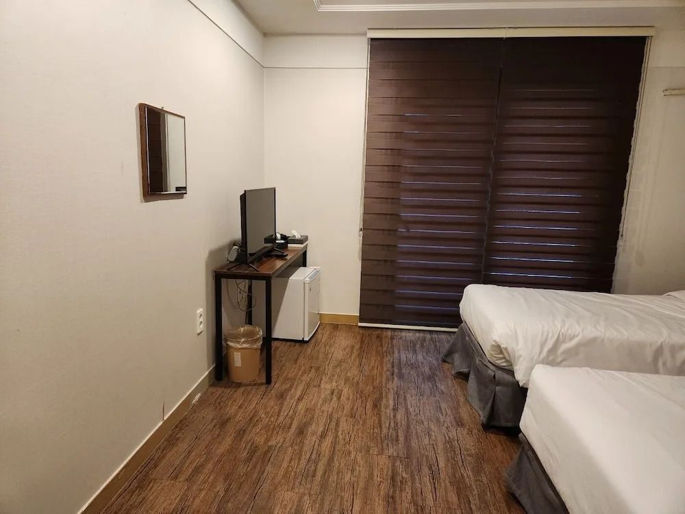 Standard Doppelzimmer mit zwei Einzelbetten und braunen Vorhängen