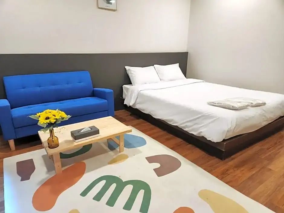 Modernes Superior Doppelzimmer mit Doppelbett und blauer Couch.