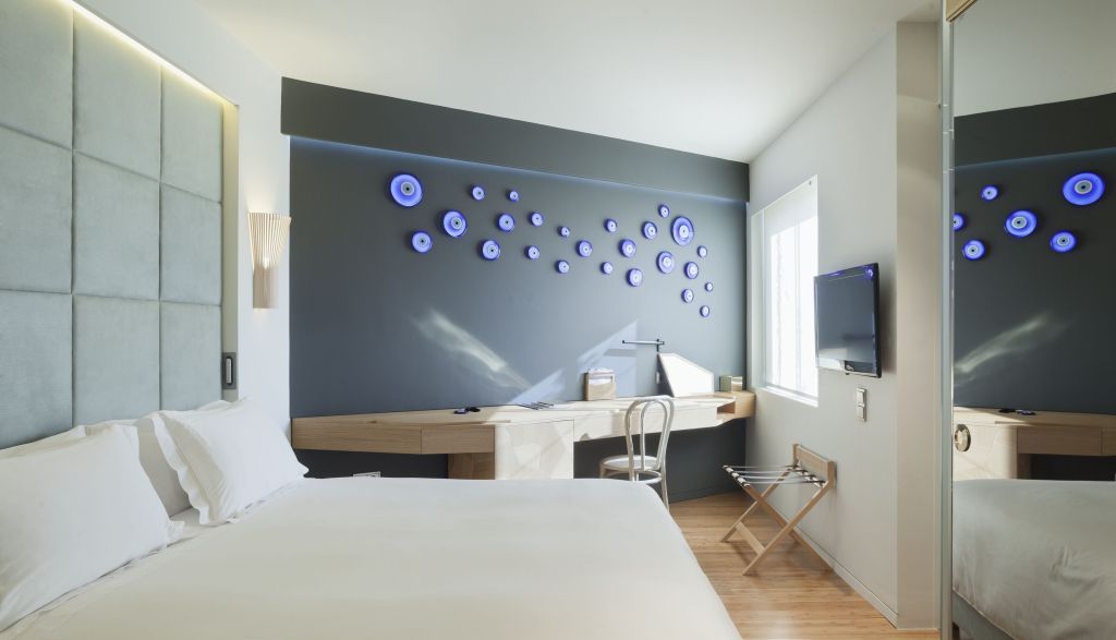Modern eingerichtetes Hotelzimmer mit Kunst an der Wand und Schreibtisch