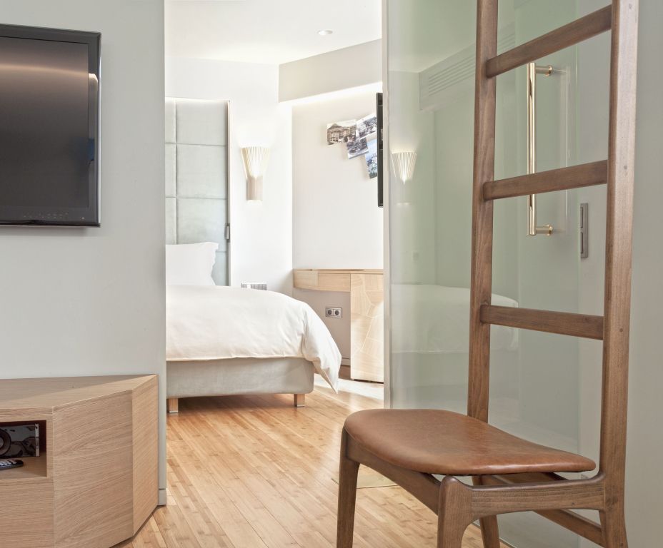 Einblick in ein helles Hotelzimmer mit elegantem Bett und Holzmöbeln