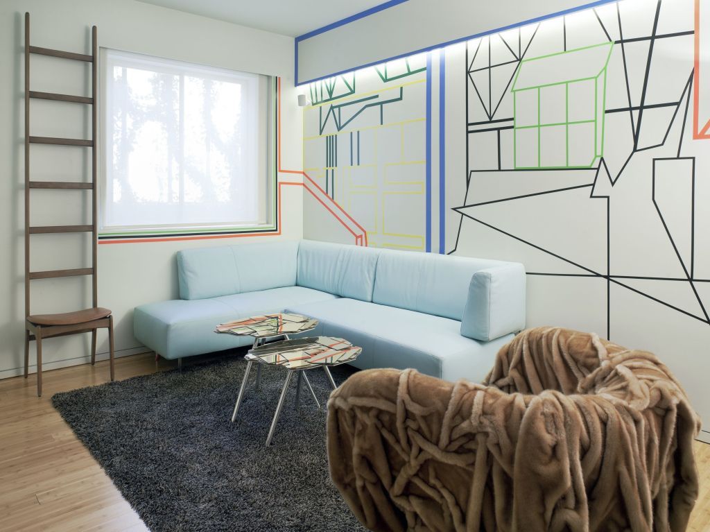 Wohnzimmer mit moderner Sofa-Landschaft und kreativem Wanddesign