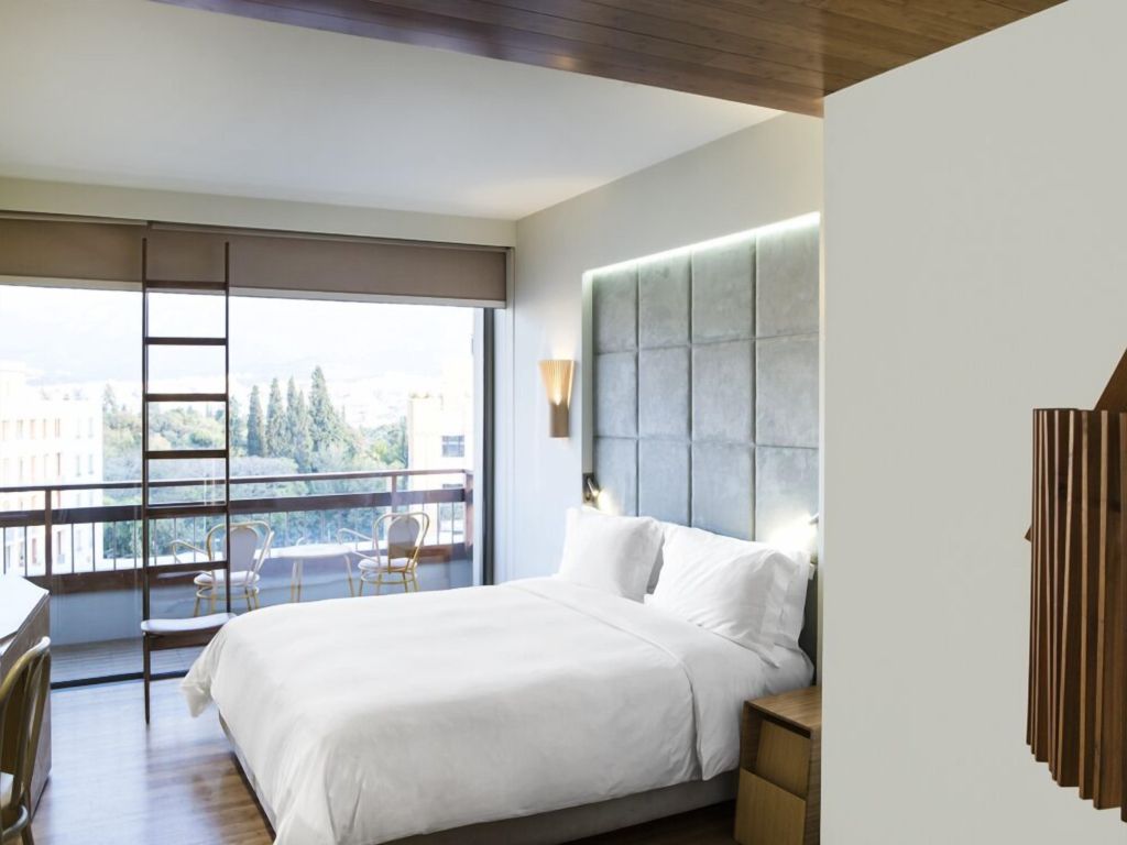 Geräumiges Zimmer mit Doppelbett und großem Fenster mit Stadtblick.