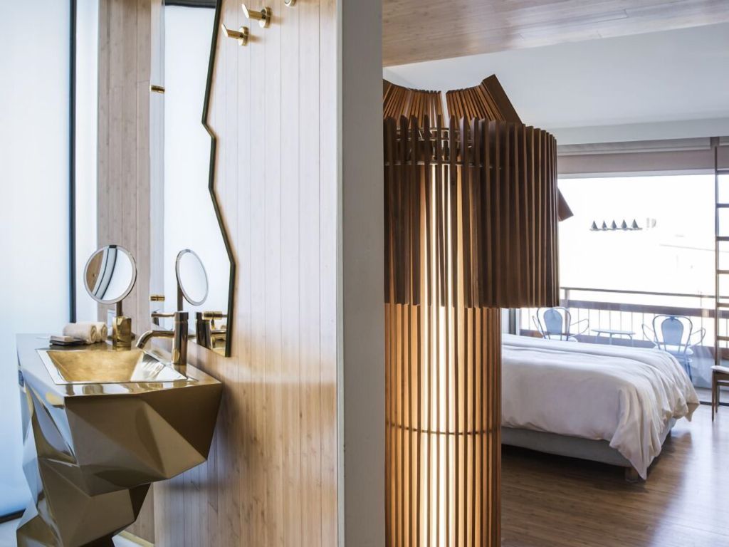 Zimmer mit einzigartigem Holzmöbel und offener Sicht zum Balkon.