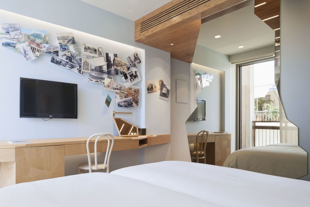 Helles Doppelzimmer mit Fotowand und Balkonzugang