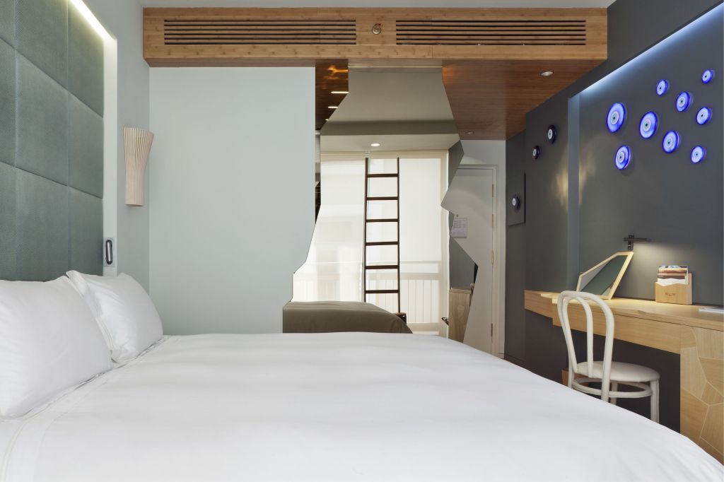 Modernes Hotelzimmer mit Doppelbett und stilvollem Wanddesign