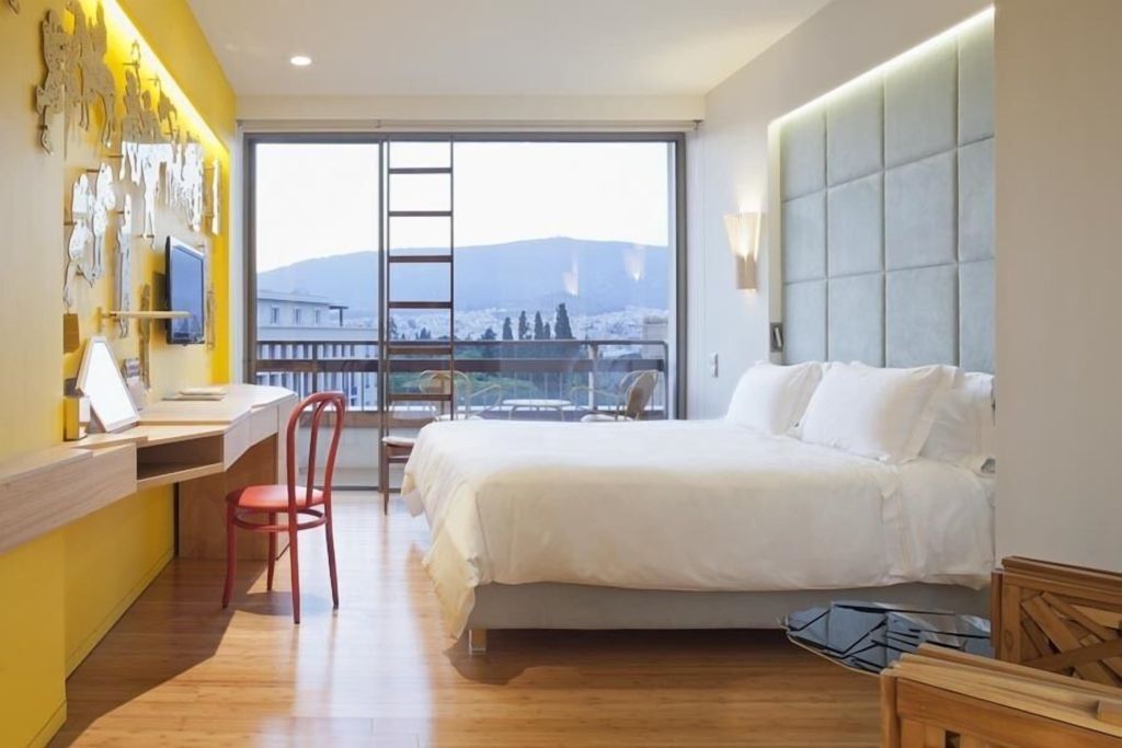 Geräumiges Hotelzimmer mit einem Doppelbett und Aussicht auf die Stadt