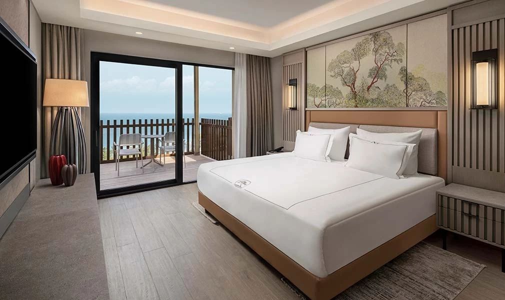 Elegantes Schlafzimmer in der Corner Suite mit Meerblick und Balkon.