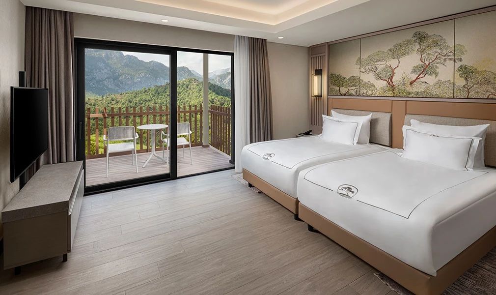 Gästezimmer mit zwei Einzelbetten in der Corner Suite mit Aussicht auf die Berge.