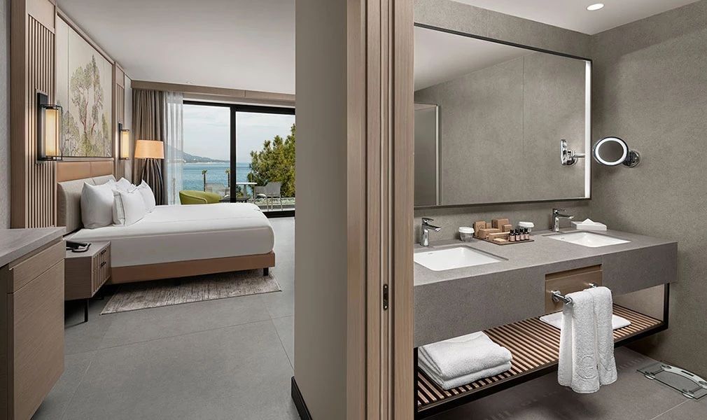 Zimmeransicht mit angrenzendem Badezimmer und Blick auf das Meer