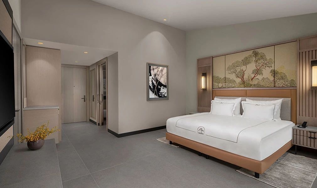 Deluxe Familienzimmer mit großem Bett und minimalistischer Einrichtung im Hotel.