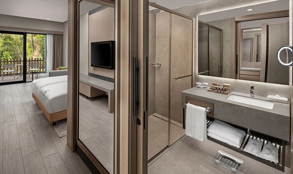 Elegantes Badezimmer mit Dusche und TV-Blick im Familienzimmer des NG Phaselis Bay Hotels