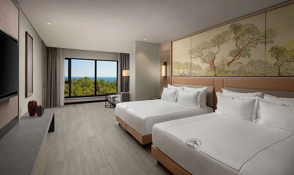 Zweibettzimmer mit großen Fenstern und Blick auf das Meer