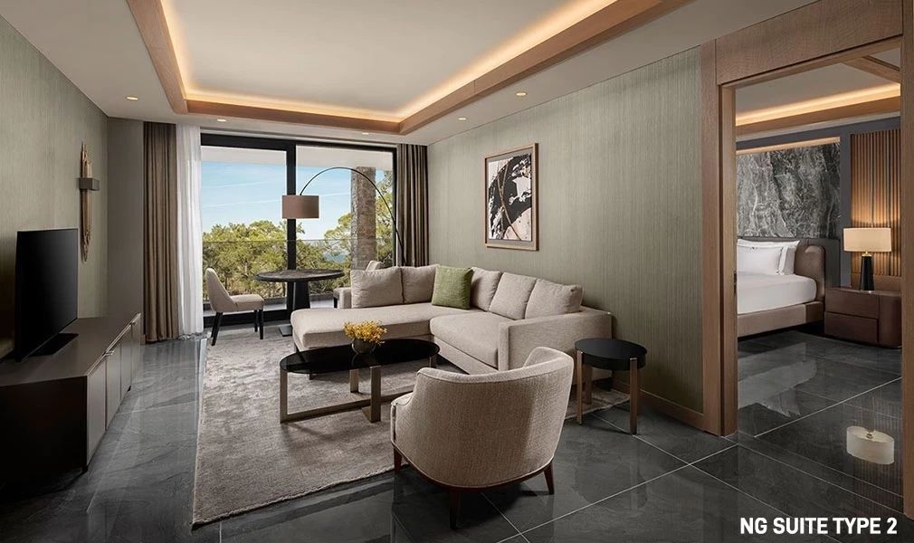 Wohnbereich mit komfortabler Couch und großem Fenster in der NG Suite