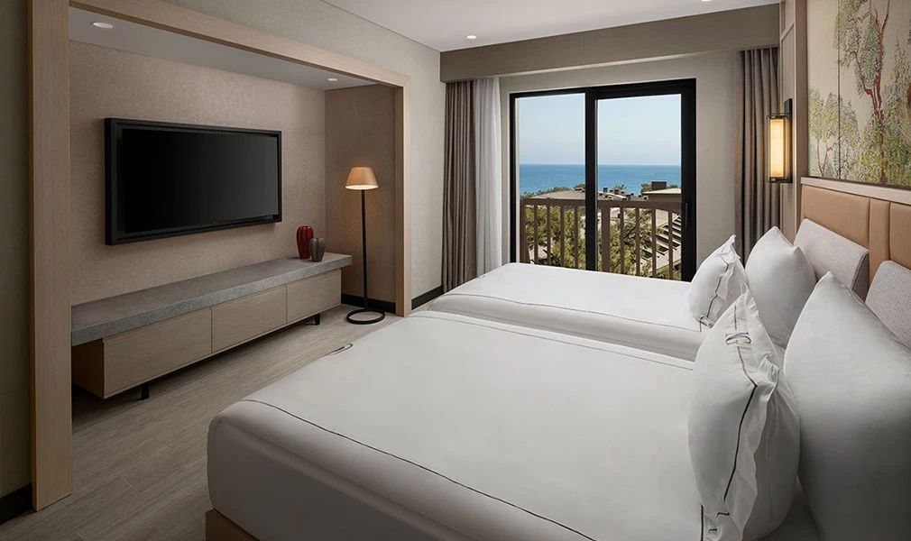 Zweibettzimmer mit großem Fenster und Blick auf das Meer
