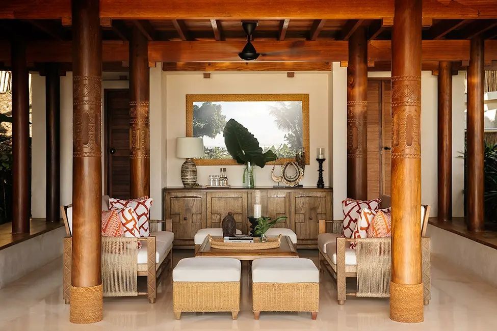 Stilvolle Lounge mit Holzmöbeln und Spiegel im Nihi Sumba Hotel.