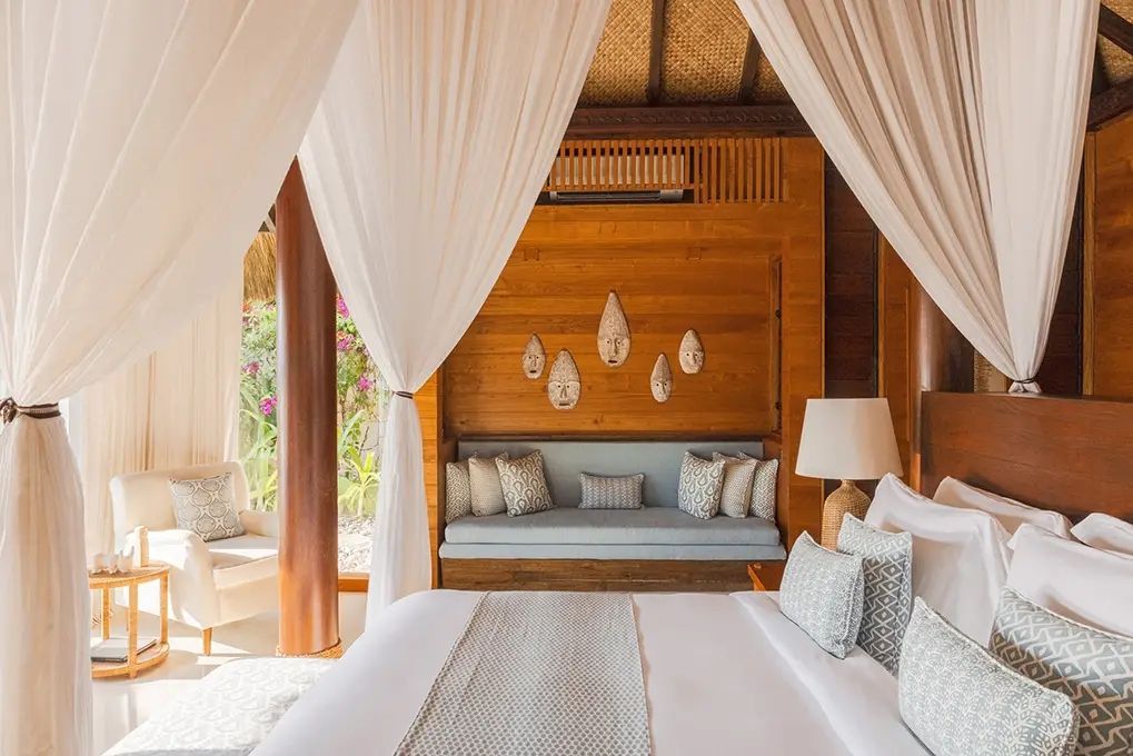 Elegantes Schlafzimmer mit großen weißen Vorhängen und Holzwänden.
