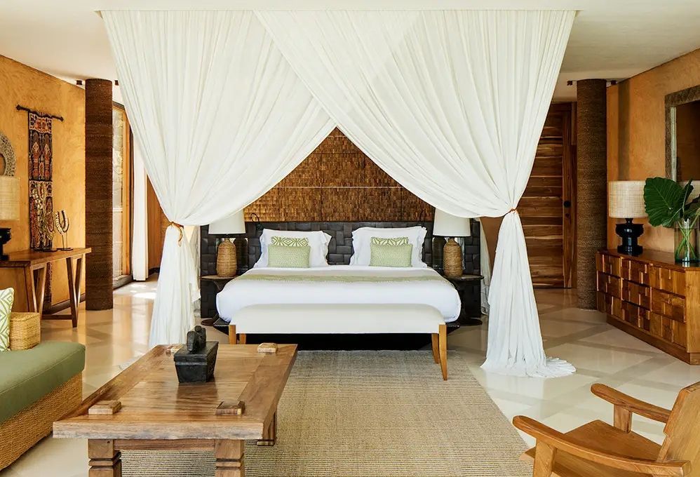 Lichtdurchflutetes Schlafzimmer in exotischer Strandvilla mit zwei Einzelbetten und Vorhängen
