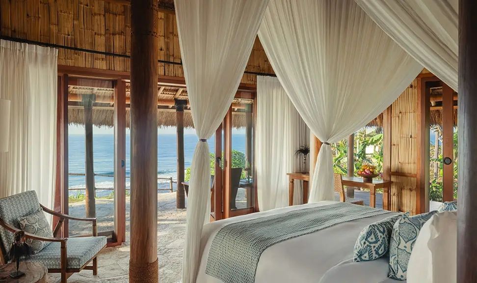 Schlafzimmer mit Meerblick in tropischer Villa, luftige Vorhänge